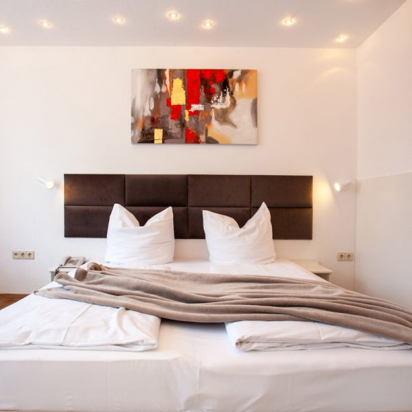 tp-hotelberatung-relax-hotel-standard-doppelzimmer-7 Doppelzimmer mit Bild an der Wand und Fleecedecke auf dem Bett